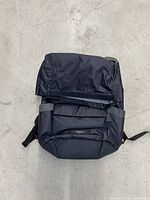 Top view of the Timbuk2 Deploy black convertible backpack pannier folded down showing roll-top closure and fabric texture.