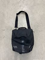 Front view of black Timbuk2 Tandem pannier convertible shoulder bag with flap and strap showing overall condition.