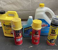 Front view of assorted auto and household products showing details of container labels and colors to identify items.