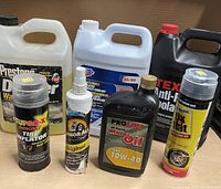 Photo of six assorted car care products including fluids and sprays.