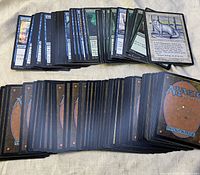 Two stacked piles of Magic The Gathering cards showing fronts of some cards and backs of others
