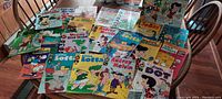 Photo showing spread of 22 vintage comic books on table, titles include Little Lulu, Little Dot, Little Lotta, Audrey Melvin, Wendy Witch World, Casper, Huey Dewey and Louie, Richie Rich