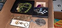 Photo showing lime green beaded necklace, matching earrings with flower design, gold-tone chain, key chain, and belt buckle.