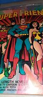 Close-up photo of the comic book cover showcasing Superman, Wonder Woman, Robin, and Batman together in classic comic style.