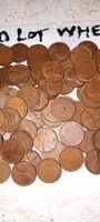 Photo showing a close-up pile of multiple vintage wheat pennies with visible wheat ear reverse and varying dates.