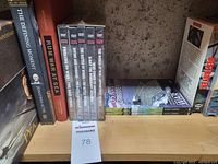 Shelf showing several books and DVD sets primarily about naval warfare and WWII history from seller's lot 78.