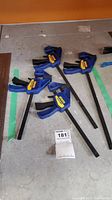 View of all four Irwin Quick-Grip clamps lying on floor showing two 12-inch and two 18-inch clamps in blue.