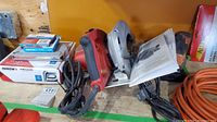 Milwaukee skill saw and some manuals, Arrow cordless staple gun box underneath, power cords visible