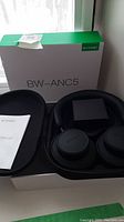 Blitzwolf BW-ANC5 headphones, carrying case, and box on windowsill.