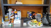 Overview of pest control supplies, spray paints, glues, tapes, gloves, and other small hardware items on shelf