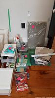 Overview of lot showing cutting mat, fabric drawer organizer, rulers, books and fabric bundles