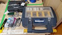 Overview of the lot including Mastercraft rotary tool case, Maximum ratchet set case, and assorted hardware on wood surface