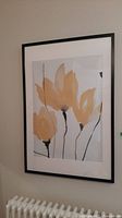 Wall print hung on wall, showing full artwork with abstract yellow-orange flower petals and black stems.