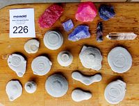 Top-down view of the full collection showing all fairy stones, quartz, and fluorite pieces arranged on a wooden surface.