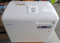Front view of white Home Bakery breadmaker with digital control panel and vent on top
