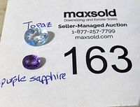 Photo of two faceted oval gemstones, labeled as topaz (light blue) and purple sapphire (violet purple).