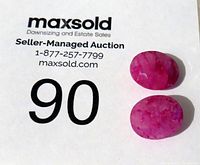 Two faceted red quartz stones placed on a Maxsold auction card, shown to indicate lot number.