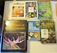 Seven wildflower and tree books arranged flat on a white surface, titles visible for identification.