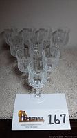 Set of ten Cristal D'Arques Longchamp Durand clear crystal stem glasses arranged on a surface, showing overall quantity and shape