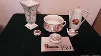Photo showing all six pieces: square vase, chamber pot, coffee pot, two covered dishes, and small teapot.