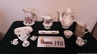 Full view of the assorted English porcelain and fine china including miniature tea set, pitchers, coffee pot, tray, creamers, sugar bowl