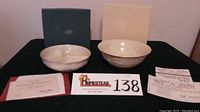 Divided server and bowl with original boxes and certificates of authenticity displayed on black surface