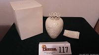 Photo showing the white Lenox vase, original box, and certificate of authenticity with lot number plate visible.