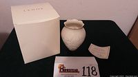 View of the Lenox box, vase, and certificate of authenticity arranged on table
