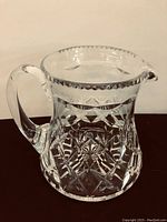 Full view of the crystal jug showing clear glass, cut diamond pattern, handle, and spout