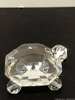 Front view of the crystal clear turtle figurine showing faceted shell and black eyes on turtle's head.
