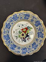 Top view of vintage ridgway john & co decorative plate showing floral pattern with blue border and gold trim