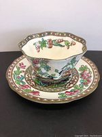Photo of vintage Coalport tea cup and saucer showing detailed floral pattern, scalloped edges, and gold trim.