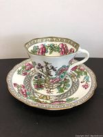 Side view of vintage Coalport tea cup on matching saucer showing floral and gold pattern details.