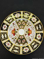 Front view of the vintage Royal Crown Derby plate showing elaborate pattern and colors of the design.