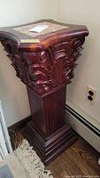 Full view of the carved wooden corner table showing the marble top and wood column base with decorative carved details.