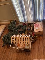 Photo showing assortment of holiday decorations including green Christmas wreaths, cardboard boxes with ornaments, fall-themed decorations, and a decorative basket.