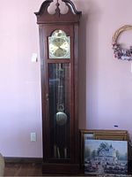 Full view of the Ridgeway grandfather clock showing wooden case, glass front, pendulum, and clock face with Roman numerals.