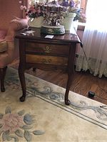Full view of the solid wood side table showing table top, legs, and two drawers with brass handles.