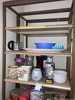 Shelving unit with assortment of glass vases, ceramic mugs, ice trays, serving platter, and decorative items