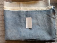 Blue fleece fabric folded with dimensions noted on paper