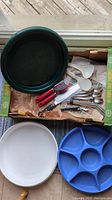 Photo showing full assortment including veggie tray, serving spoons, cutlery, can opener, corkscrew, metal straws, and spoons.