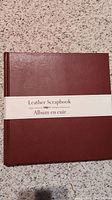 Photo of front cover of the burgundy leather scrapbook album with paper band labeling it as Leather Scrapbook Album.