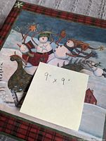 Winter scene scrapbook cover showing snowmen and lantern design with size note of 9x9 inches.