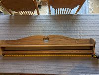 Full view of the oak quilt rack shelf laid flat showing length and front rail for hanging quilts.