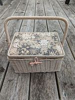 Woven basket with floral tapestry lid and handle, closed, showing front and latch