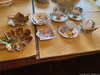 Overall lot of porcelain including cups, saucers, leaf dishes and small plates arranged on table