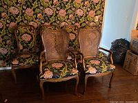 Six dining chairs displayed - four side chairs with floral fabric upholstery, two armchairs with cane backs and floral upholstered seats.