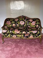 Front view of Louis XV style settee showing floral upholstery and damaged wooden frame.