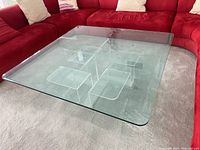 Top angle view of the coffee table showing the square glass top and lucite geometric base inside.