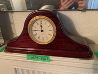 Mantle clock showing full wooden case and shape
